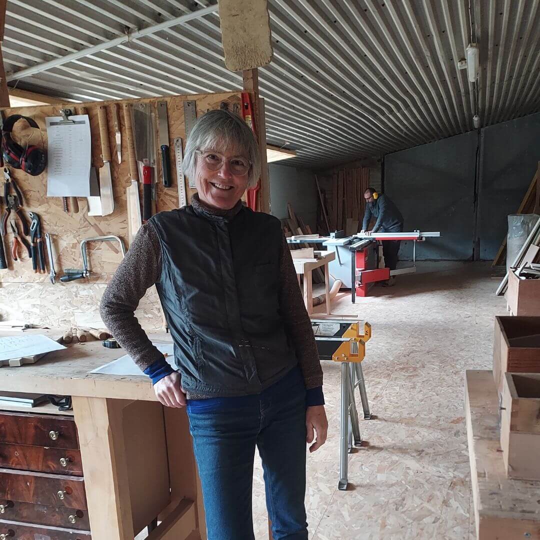 Cécile Gareyte artisan ébéniste devant son établi, en fond Mathieu de Loup Bois sur la scie à format